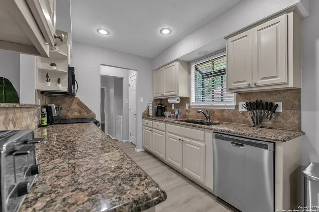 a kitchen with stainless steel appliances granite countertop a sink stove and cabinets