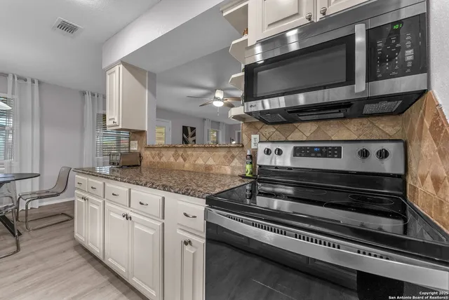 a kitchen with stainless steel appliances granite countertop a stove and a microwave