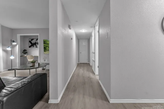 a view of a hallway with wooden floor