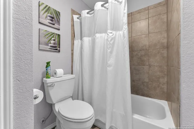 a white toilet sitting next to a bath tub shower
