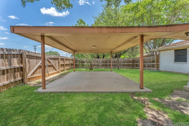 a view of a backyard with grass and a garden