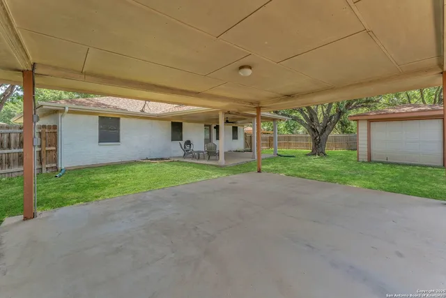 a view of a house with a yard and large parking space