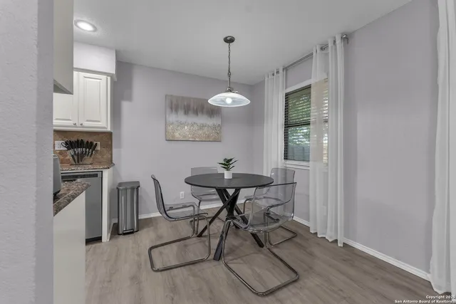 a kitchen with stainless steel appliances a dining table chairs and granite counter tops