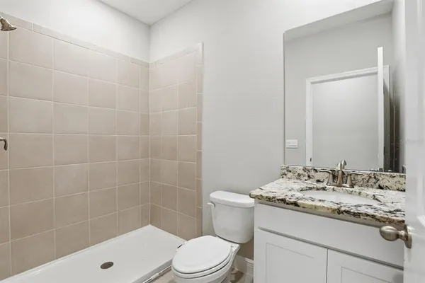 a bathroom with a sink a toilet a mirror and shower