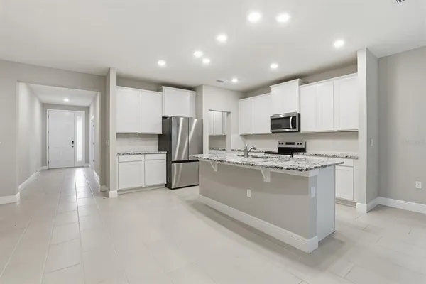 a kitchen with a refrigerator and a stove top oven