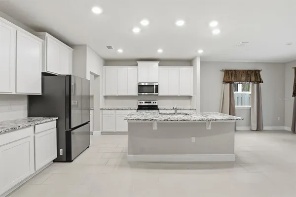 a kitchen with stainless steel appliances granite countertop a stove a refrigerator and a refrigerator