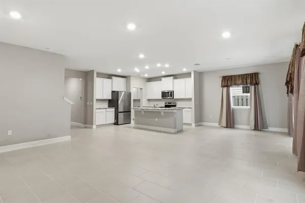 a view of kitchen with refrigerator and window