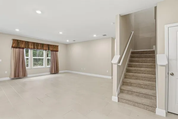 a view of an empty room with a fireplace and stairs