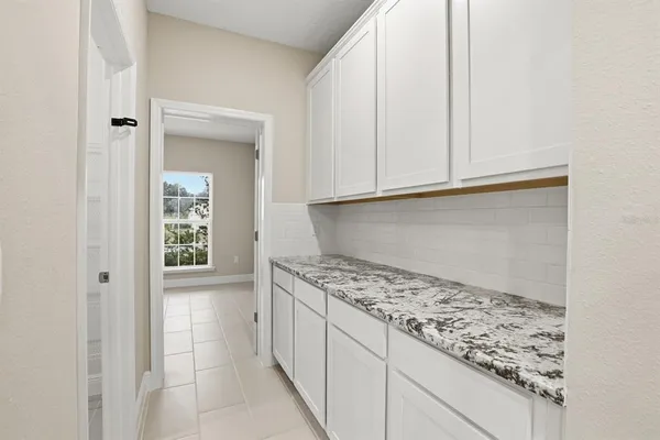 a kitchen with granite countertop white cabinets and sink