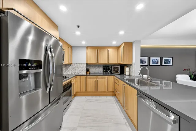 a large kitchen with a large counter top stainless steel appliances and cabinets