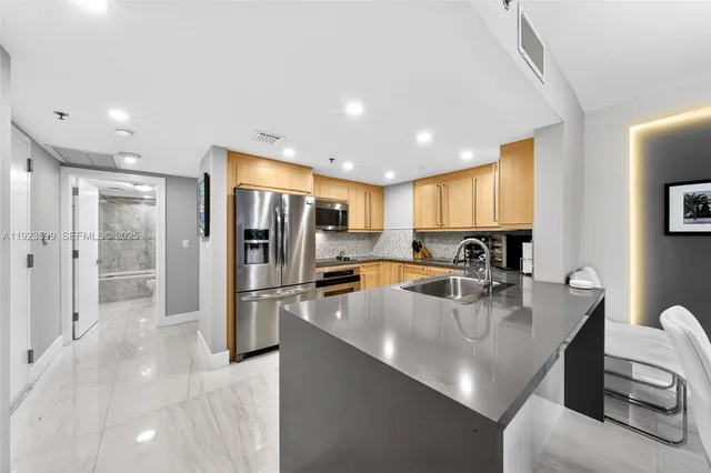 a large kitchen with stainless steel appliances lots of counter space and a sink