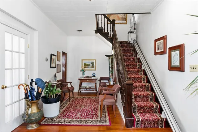a view of hallway with wooden floor and a rug