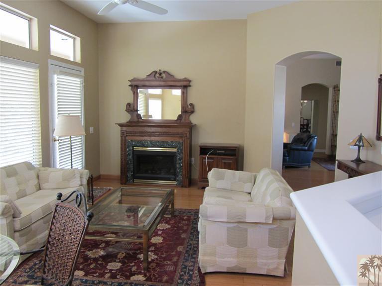 78591 Dancing Waters Road Palm Desert, CA 92211 - Photo 10 of 17 a living room with furniture a flat screen tv and a fireplace
