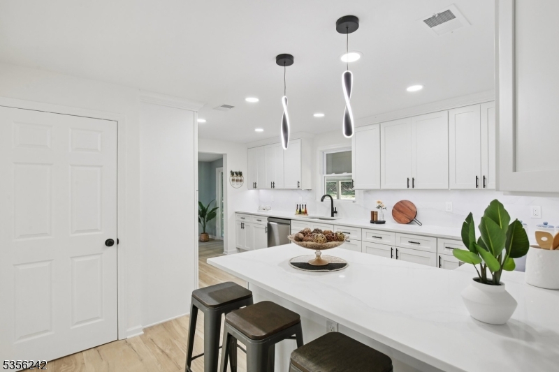 16 Wildcat Road Sparta, NJ 07871 - Photo 11 of 38 a kitchen with a sink a white cabinetry and chairs