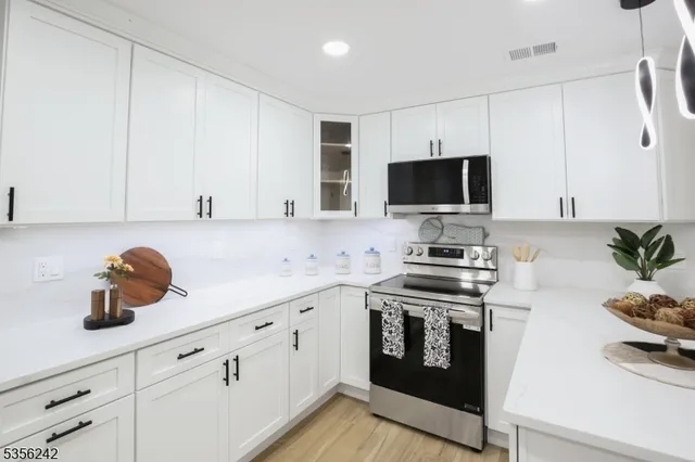 a kitchen with appliances a sink and cabinets