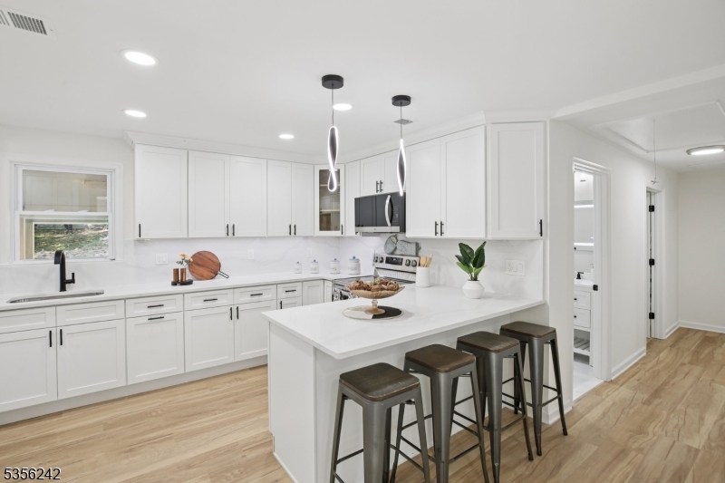 16 Wildcat Road Sparta, NJ 07871 - Photo 14 of 38 a kitchen with white cabinets and chairs
