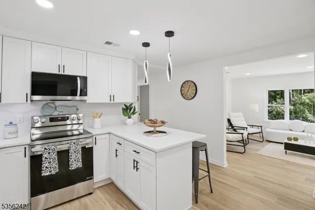 a view of kitchen with cabinets stove and wooden floor