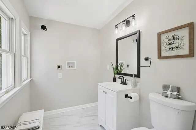 a bathroom with a toilet a sink and a mirror