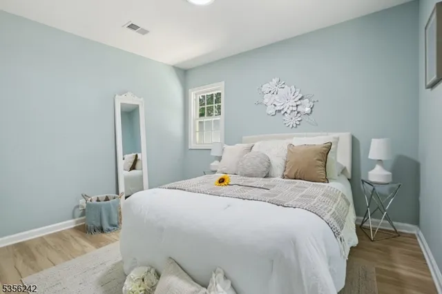 a bedroom with bed and wooden floor