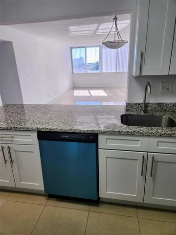 a kitchen with granite countertop a sink and a stove