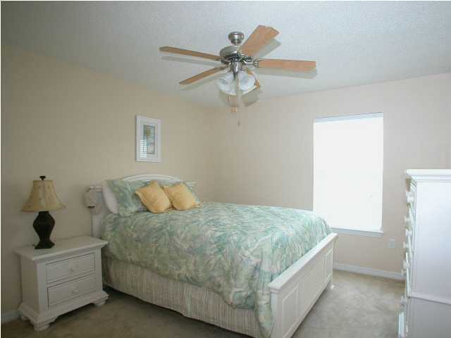 138 South Harborview Road Santa Rosa Beach, FL 32459 - Photo 10 of 12 a bedroom with a bed and a chandelier