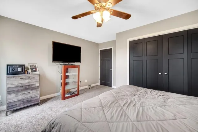 a bedroom with a bed and a flat tv screen on dresser