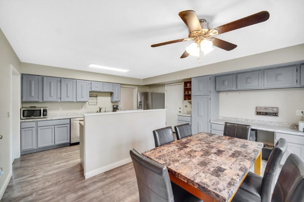 809 West 126th Court Crown Point, IN 46307 - Photo 20 of 47 a kitchen with stainless steel appliances kitchen island granite countertop a table chairs in it and wooden floors