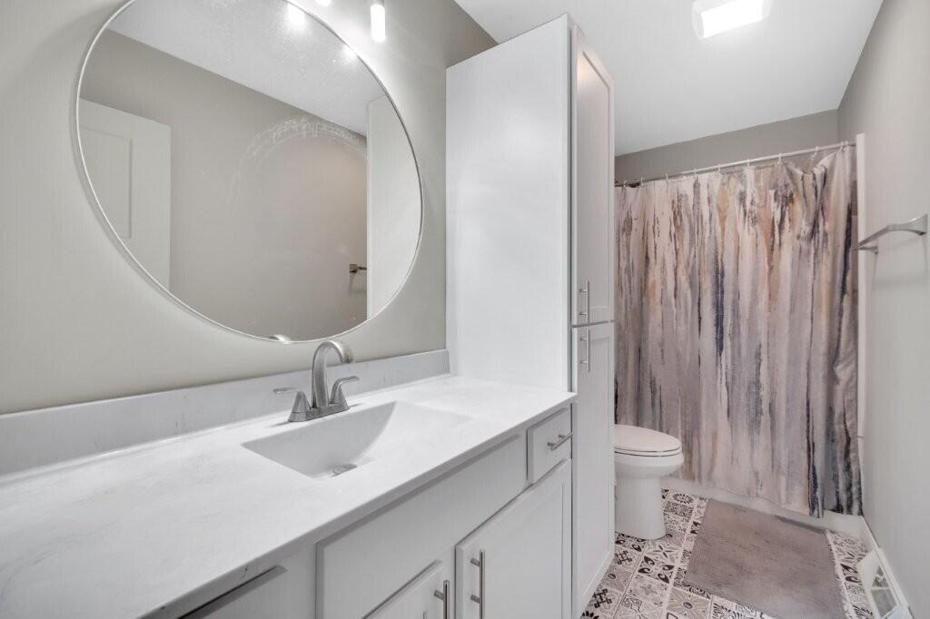809 West 126th Court Crown Point, IN 46307 - Photo 30 of 47 a bathroom with a sink toilet a mirror and vanity
