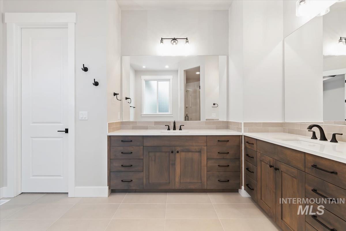 2147 East Blakehurst Avenue Kuna, ID 83634 - Photo 22 of 43 Full bath featuring vanity, a shower stall, light tile patterned flooring, and backsplash
