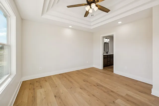 an empty room with a ceiling fan and a window