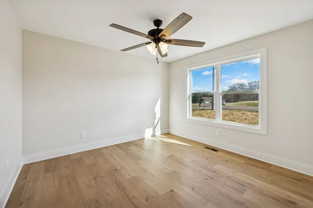 wooden floor in an empty room with a window