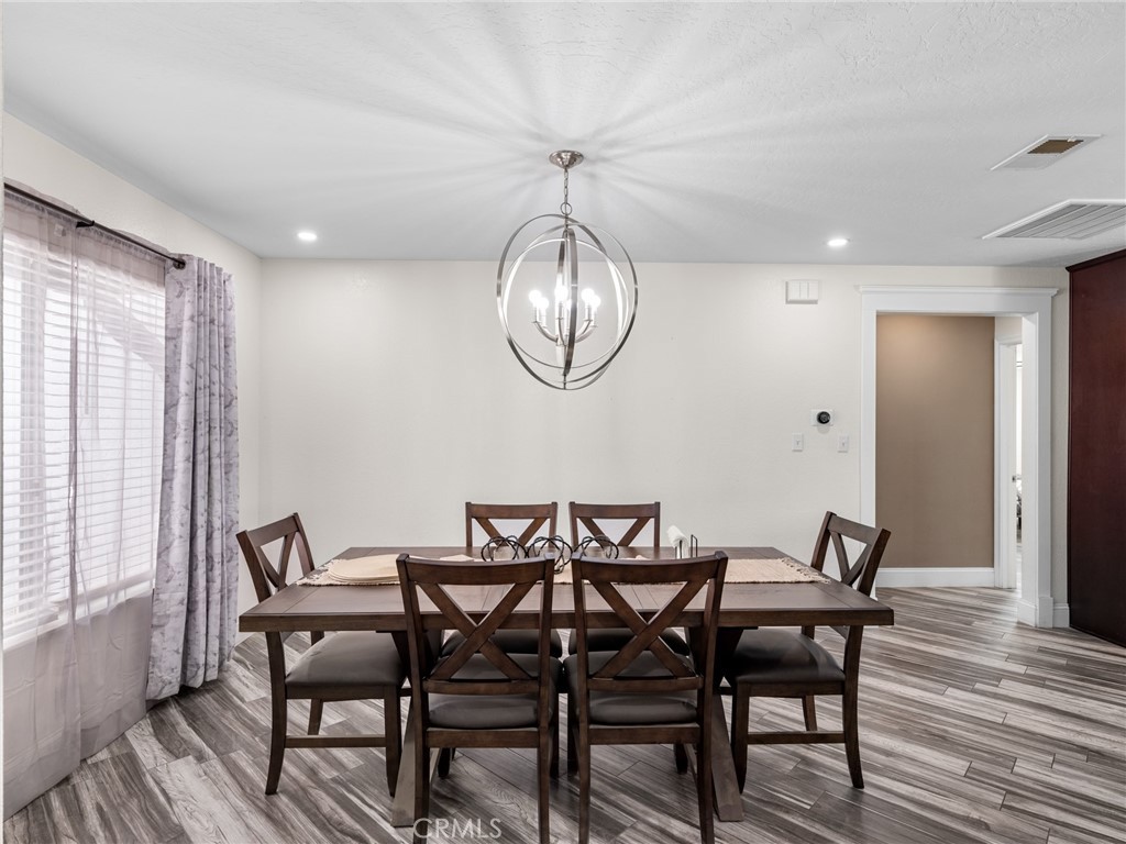 15485 Chole Road Apple Valley, CA 92307 - Photo 13 of 60 a dining room with furniture a chandelier and wooden floor