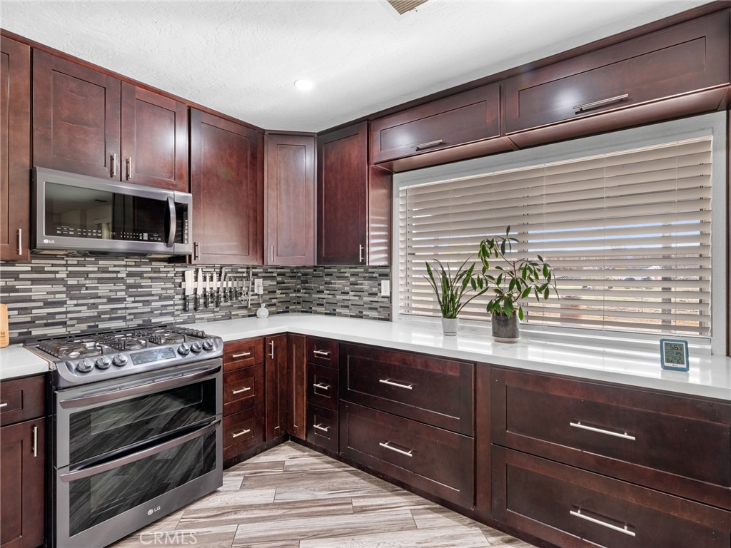 15485 Chole Road Apple Valley, CA 92307 - Photo 16 of 60 a kitchen with stainless steel appliances granite countertop wooden cabinets and a stove top oven