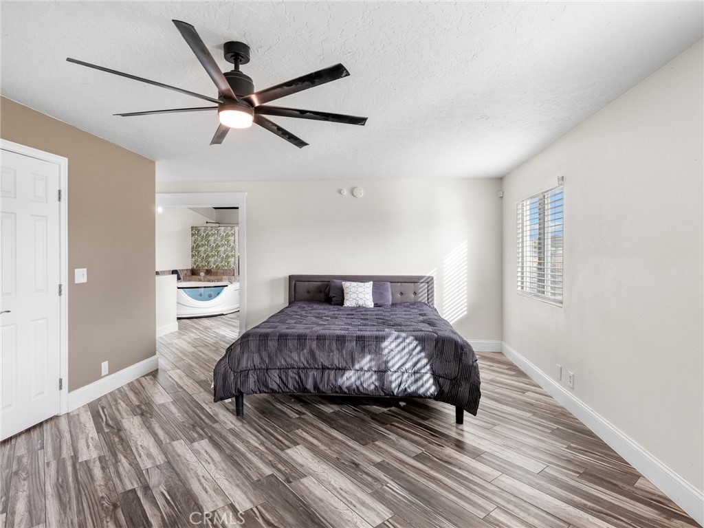 15485 Chole Road Apple Valley, CA 92307 - Photo 33 of 60 a bedroom with a large bed chandelier and a window