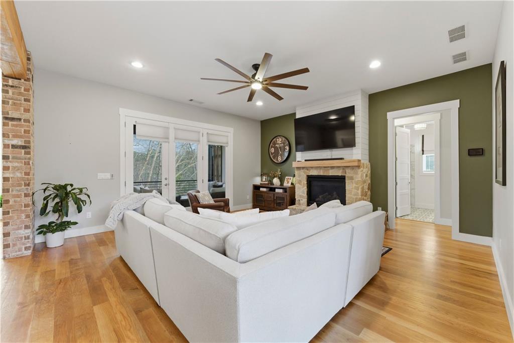 6754 Gaines Ferry Road Flowery Branch, GA 30542 - Photo 14 of 85 a living room with furniture a flat screen tv and a fireplace