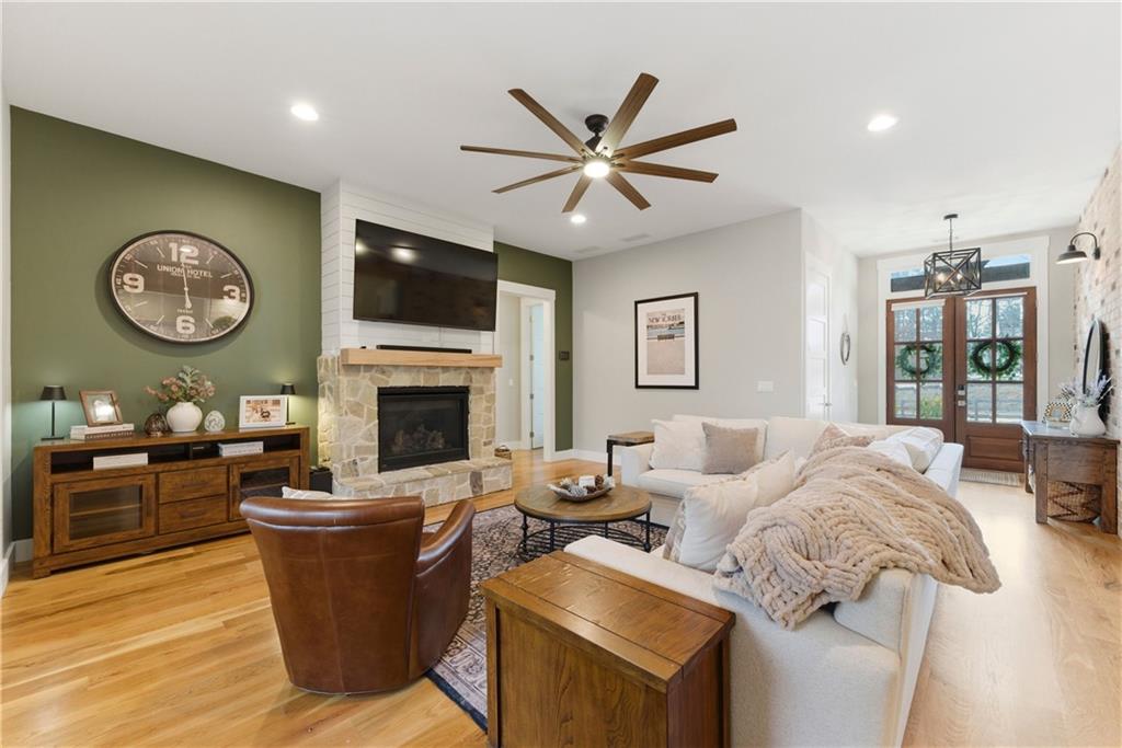 6754 Gaines Ferry Road Flowery Branch, GA 30542 - Photo 15 of 85 a living room with furniture a flat screen tv and a fireplace