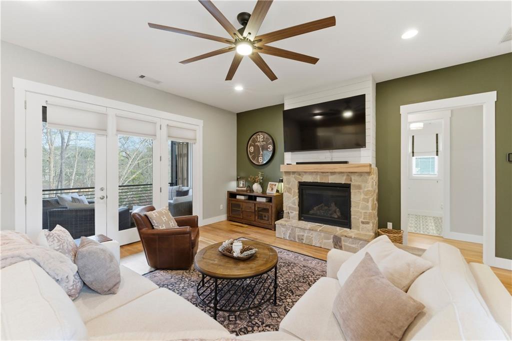 6754 Gaines Ferry Road Flowery Branch, GA 30542 - Photo 16 of 85 a living room with furniture a fireplace and a flat screen tv