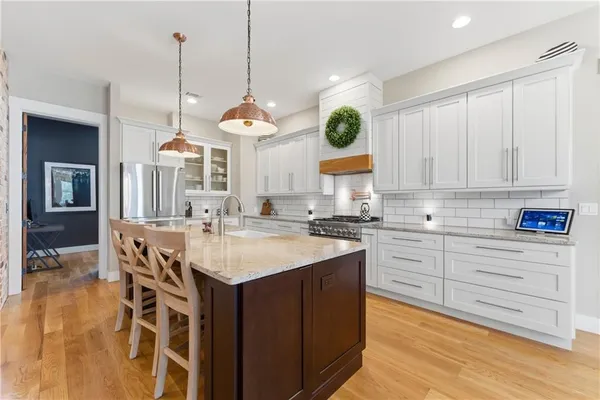 a kitchen with stainless steel appliances granite countertop a stove a sink and a white cabinets