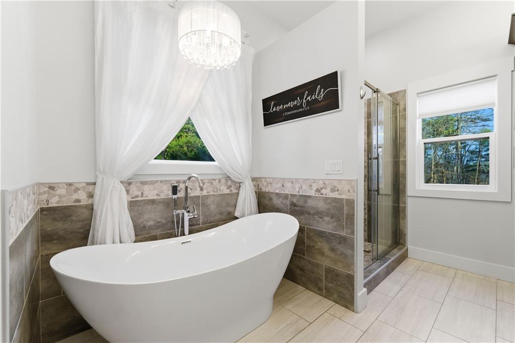 6754 Gaines Ferry Road Flowery Branch, GA 30542 - Photo 36 of 85 a white bath tub sitting in a bathroom next to a window