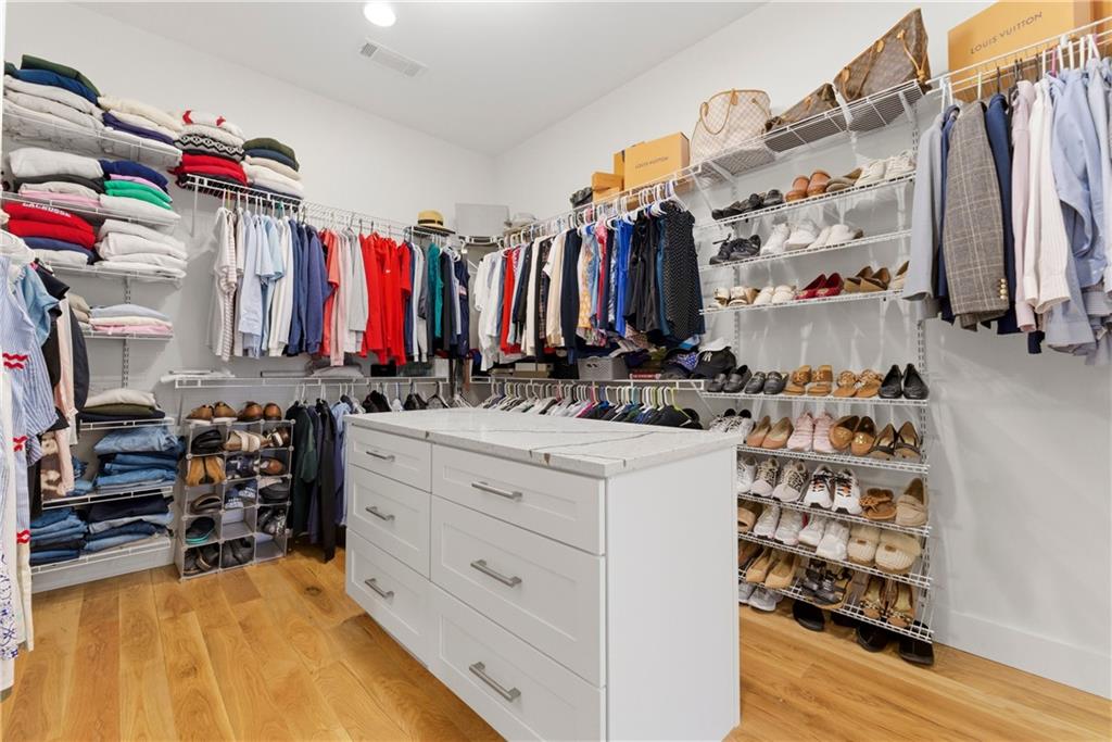 6754 Gaines Ferry Road Flowery Branch, GA 30542 - Photo 38 of 85 a view of walk in closet with clothes and shoes