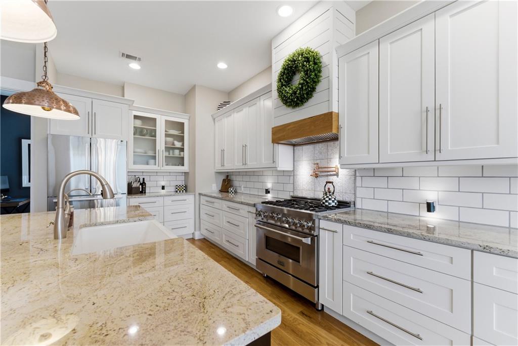 6754 Gaines Ferry Road Flowery Branch, GA 30542 - Photo 4 of 85 a kitchen with stainless steel appliances granite countertop a stove a sink and a white cabinets