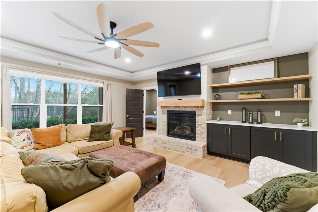 6754 Gaines Ferry Road Flowery Branch, GA 30542 - Photo 56 of 85 a living room with furniture a fireplace and a flat screen tv