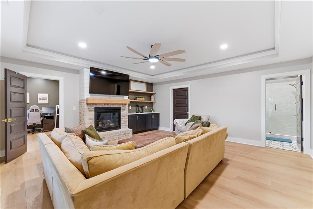 6754 Gaines Ferry Road Flowery Branch, GA 30542 - Photo 57 of 85 a living room with furniture a fireplace and a flat screen tv
