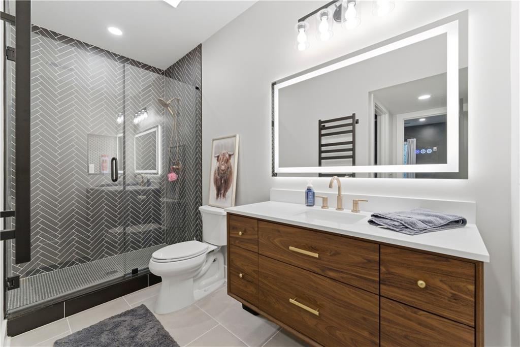 6754 Gaines Ferry Road Flowery Branch, GA 30542 - Photo 60 of 85 a bathroom with a granite countertop sink toilet mirror and shower