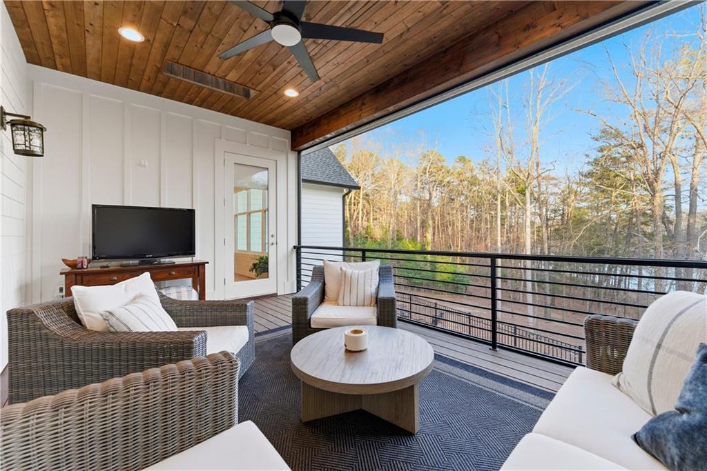 6754 Gaines Ferry Road Flowery Branch, GA 30542 - Photo 62 of 85 a living room with furniture a flat screen tv and a floor to ceiling window