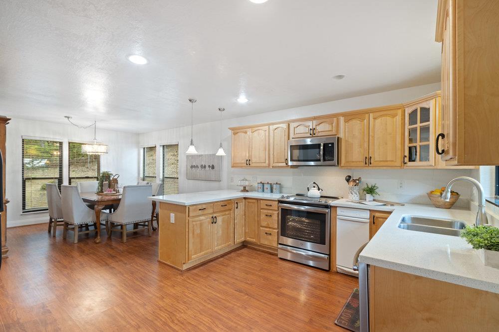 22101 Miller Ridge Road Los Gatos, CA 95033 - Photo 14 of 76 a kitchen with stainless steel appliances granite countertop wooden cabinets a sink a stove a dining table and chairs