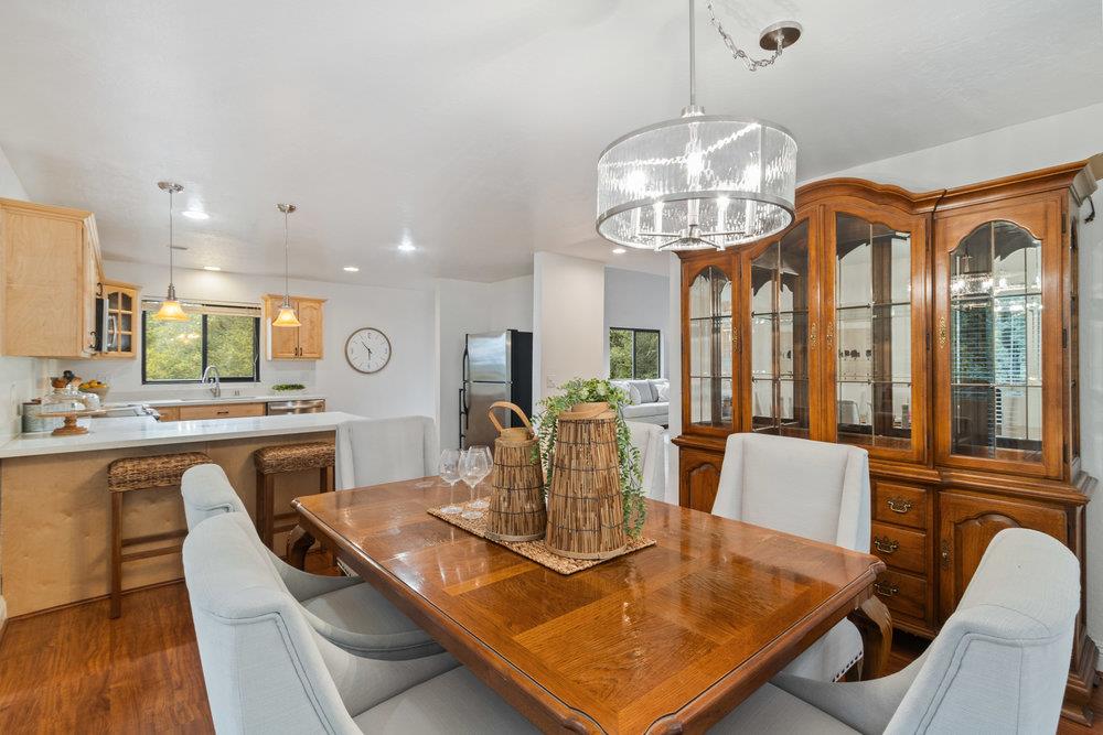 22101 Miller Ridge Road Los Gatos, CA 95033 - Photo 20 of 76 a view of a dining room with furniture a chandelier and wooden floor