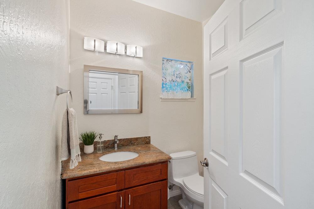22101 Miller Ridge Road Los Gatos, CA 95033 - Photo 42 of 76 a bathroom with a granite countertop sink a toilet and a mirror
