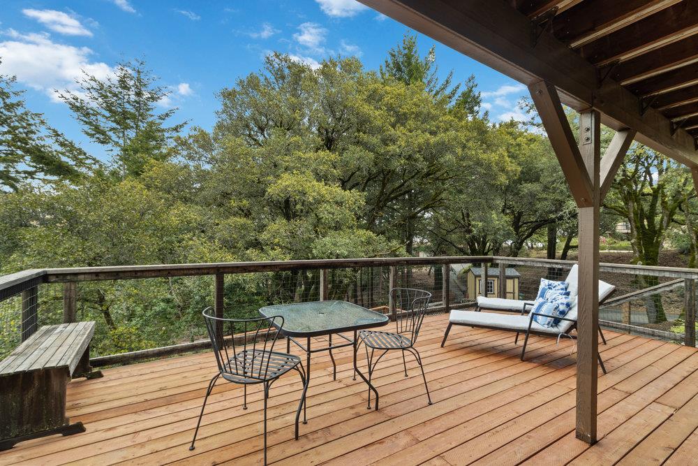 22101 Miller Ridge Road Los Gatos, CA 95033 - Photo 52 of 76 a view of a balcony with wooden floor and outdoor seating