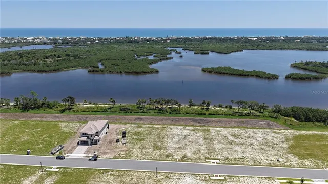 an aerial view of a residential houses with outdoor space and lake view